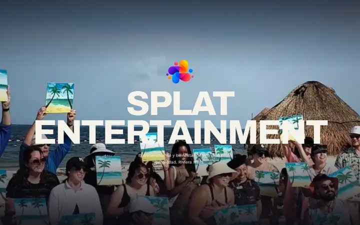 La portada de splatentertainment.com en la compu: un grupo en la playa, junto a una palapa, enseñando los cuadros que pintaron, y el nombre Splat Entertainment.